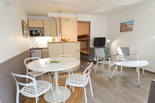 une pièce avec une table et des chaises et une cuisine dans l'établissement La Baie - Hoedic By Tranquil at Home, à La Baule