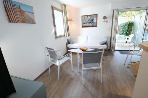 un salon avec une table, des chaises et un canapé dans l'établissement La Baie - Hoedic By Tranquil at Home, à La Baule