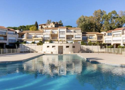 un bassin d'eau devant certains bâtiments dans l'établissement Appt 27m2 - parking - wifi - clim - piscine, à Roquebrune-sur Argens