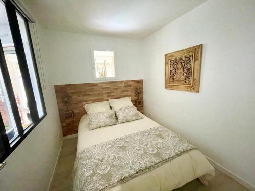 une chambre avec un lit et un tableau au mur dans l'établissement Appt 27m2 - parking - wifi - clim - piscine, à Roquebrune-sur Argens