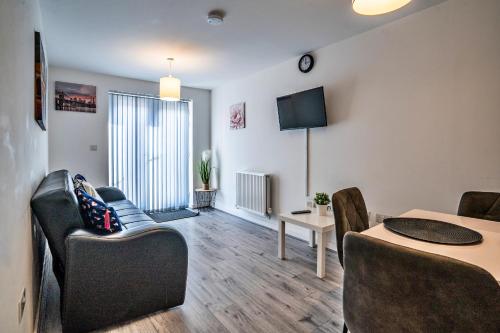 a living room with a table and chairs and a television at One-bedroom ground floor apartment in Birmingham with parking in Birmingham
