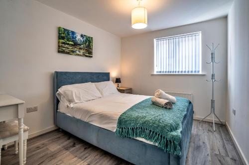 a bedroom with a bed with a blue headboard at One-bedroom ground floor apartment in Birmingham with parking in Birmingham