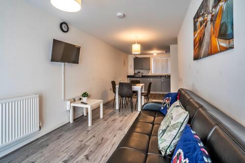 a living room with a couch and a table at One-bedroom ground floor apartment in Birmingham with parking in Birmingham