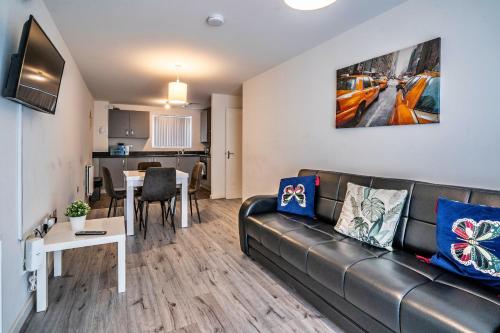 a living room with a couch and a table at One-bedroom ground floor apartment in Birmingham with parking in Birmingham