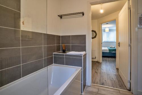 a bathroom with a bath tub in a room at One-bedroom ground floor apartment in Birmingham with parking in Birmingham