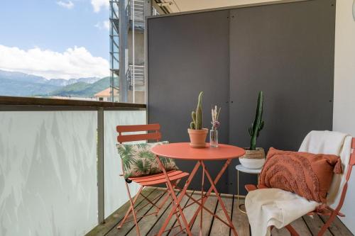 d'un balcon avec une table et des chaises rouges ainsi qu'une fenêtre. dans l'établissement Annecy, calme, terrasse, parking box, à Annecy