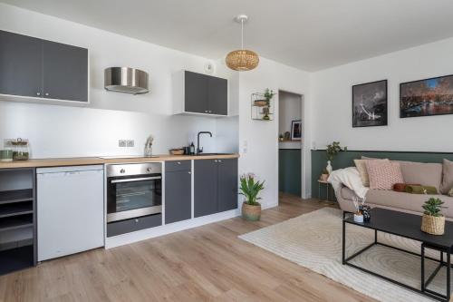 une cuisine et un salon avec un canapé et une table dans l'établissement Annecy, calme, terrasse, parking box, à Annecy