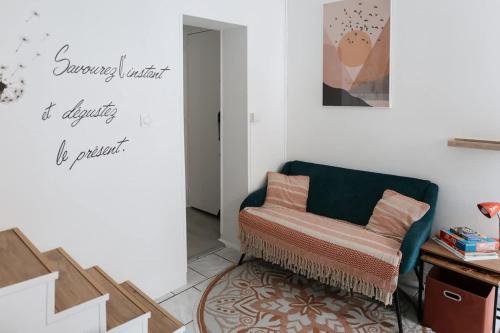 un salon avec une chaise et un miroir dans l'établissement Maison Floquet - Equipée, calme, 2 chambres, à Amiens