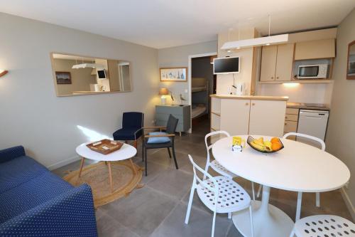 une cuisine et un salon avec une table et des chaises dans l'établissement La Baie - Houat By Tranquil at Home, à La Baule