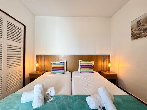 two beds in a small room with two towels at Albufeira Ocean View III by Homing in Albufeira