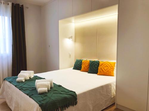 a bedroom with a large bed with towels on it at Casa Guilhermina in Lagoa