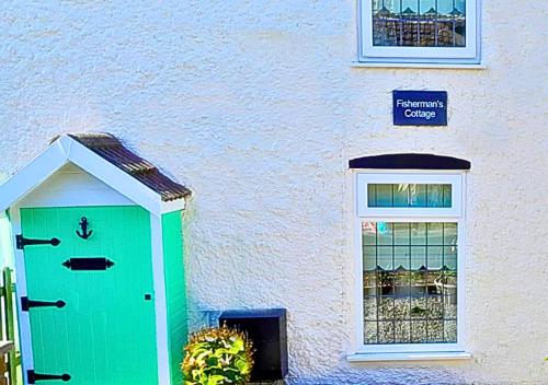 a green door on the side of a building at Romantic Lakeside Cottage by the Beach! with Super Cosy Log Burner! The Perfect Escape to Your Home from Home by the Sea! So Relaxing - You Won't want to Leave! Pet Friendly! in Mablethorpe