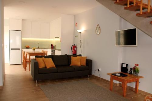 a living room with a couch and a kitchen at Casa Guilhermina in Lagoa