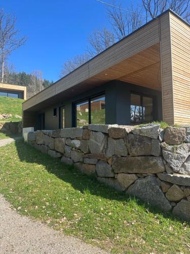 a stone retaining wall in front of a building at Domaine de Haslach, The Originals Collection, Résidence de Tourisme in Munster