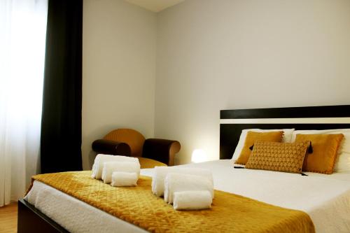 a bedroom with a large bed with towels on it at Casa Guilhermina in Lagoa