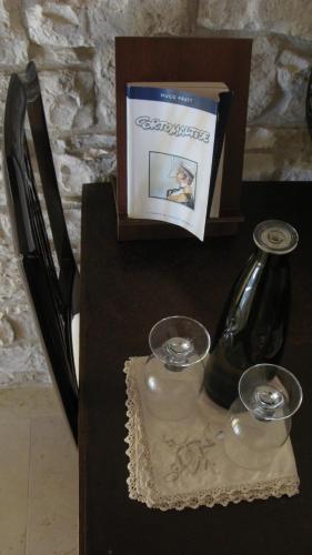 a table with a bottle and two glasses and a box at Il Mulino di Amleto - Bed and Breakfast letterario in Molfetta