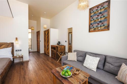 a living room with a couch and a table at Clove Island Essence & Spa Boutique in Matemwe
