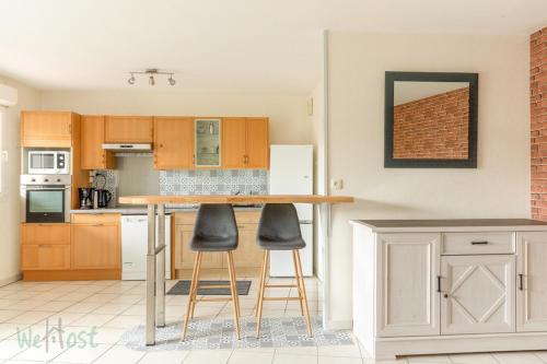 - une cuisine avec un comptoir et des tabourets dans l'établissement FRANCIS LE CARVAL - REZE - balcon - parking, à Rezé