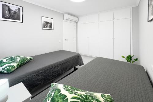 - une chambre avec 2 lits et des murs blancs dans l'établissement Casa Olivia with pool heating fee, à Torrevieja