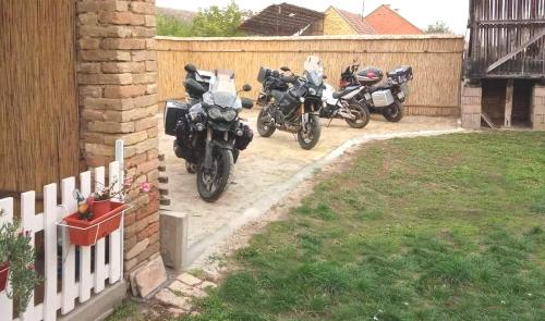 three motorcycles parked in a yard next to a fence at Kod Bake in Novi Bečej
