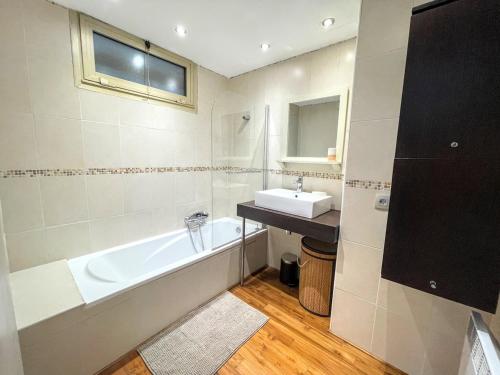 une salle de bain avec une baignoire et un lavabo dans l'établissement Serenity YourHostHelper, à Antibes