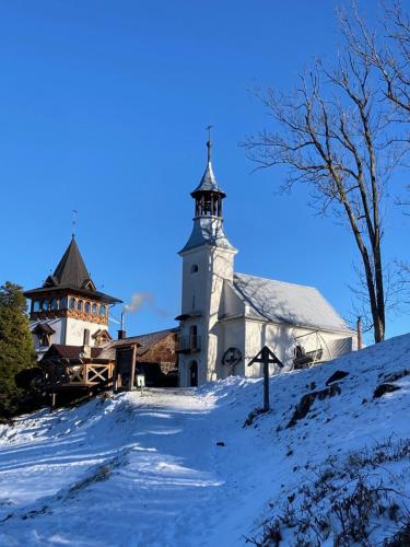 a large white church with a steeple in the snow at Chalupa Jája a Pája Tomíkovice in Jeseník