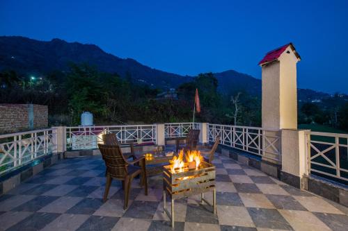 una hoguera en un patio con mesa y sillas en Alaya Stays Clouds Nest 4-BHK Retreat With Terrace & Hill Views by Naukuchiatal, en Bhimtal