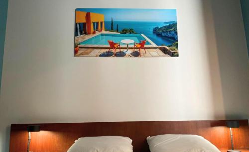 ein Schlafzimmer mit einem Bett und einem Bild von einem Pool in der Unterkunft Les Loges du Théâtre Monsigny, Centre-ville in Boulogne-sur-Mer