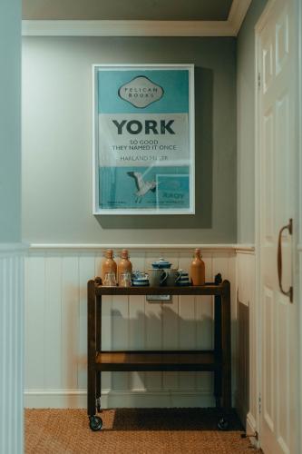 a table in a hallway with a picture on the wall at The Rudloe Near Bath - Marco Pierre White in Corsham