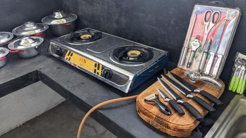 una estufa sentada en una mesa con un montón de cuchillos en Sandy Coconut Guest, en Mirissa