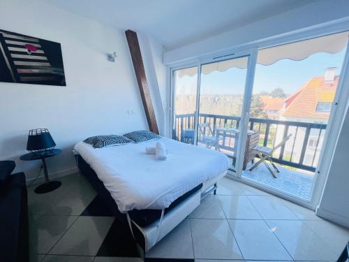 une chambre avec un lit et une vue sur un balcon dans l'établissement Joli studio Deauville, à Deauville