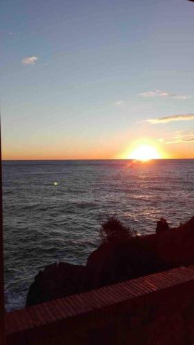 a sunset over the ocean with the sun setting at Vibes 5terre in Riomaggiore