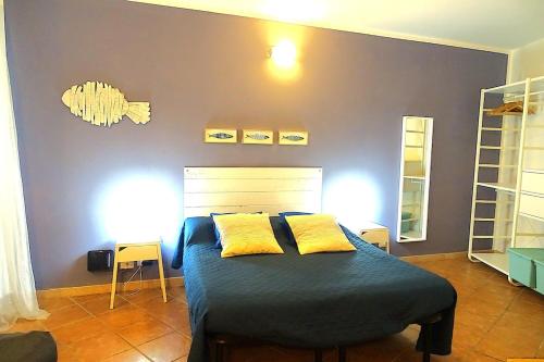 a bedroom with a bed with two yellow pillows at Vibes 5terre in Riomaggiore