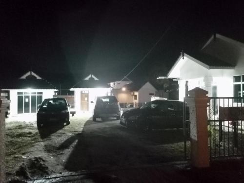 a group of cars parked in a parking lot at night at CC HOMESTAY PRIVATE POOL Kampung Mangkuk, Terengganu in Penarek