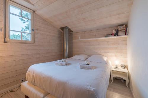 une chambre avec un grand lit blanc avec une fenêtre dans l'établissement La Gravette - 650m de la plage - Parking, à La Plaine-sur-Mer