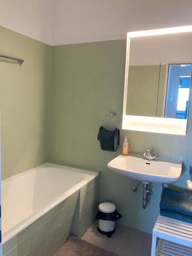 a bathroom with a sink and a bath tub and a mirror at Unique Penthouse Joseph II von Habsburg 1-4 personnes à coté de Louis Vuitton in Luxembourg