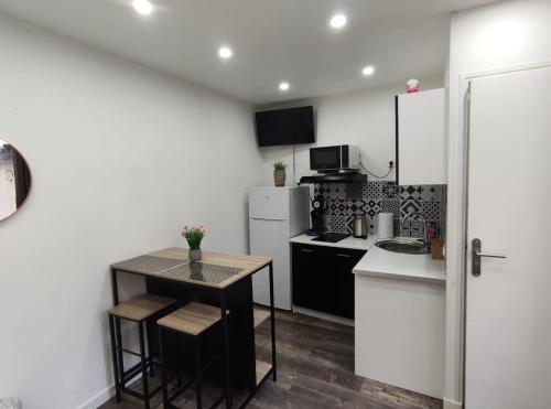 - une petite cuisine avec une table et un comptoir dans l'établissement ღ NeoNest - Studio Hyper Centre , Wifi & Cour, à Douai