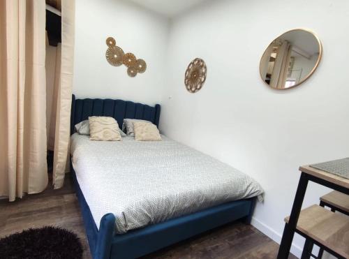 - un lit bleu dans une chambre avec un miroir dans l'établissement ღ NeoNest - Studio Hyper Centre , Wifi & Cour, à Douai
