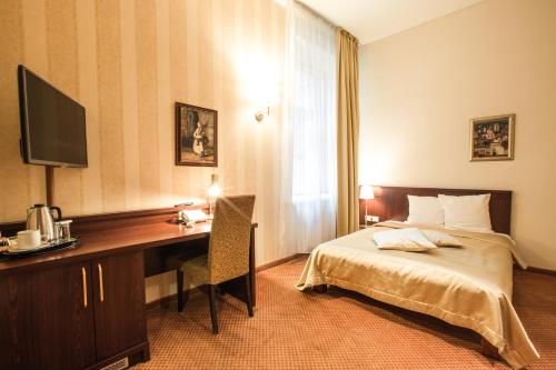 a hotel room with a bed and a desk with a computer at Monika Centrum Hotels in Rīga