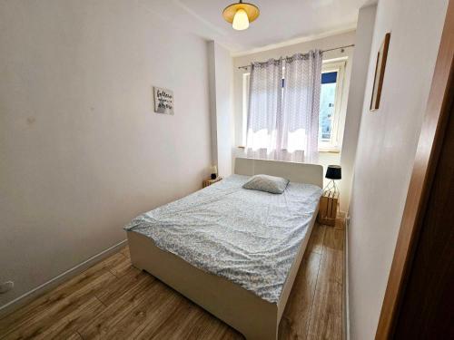 ein kleines Schlafzimmer mit einem Bett und einem Fenster in der Unterkunft Green Kabaty Apartment 3 in Warschau
