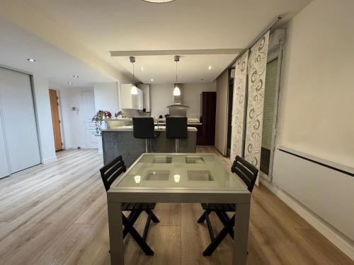 une salle à manger et une cuisine avec une table et des chaises dans l'établissement T3 terrasse-parking Groupama Stadium LDLCArena, à Décines-Charpieu