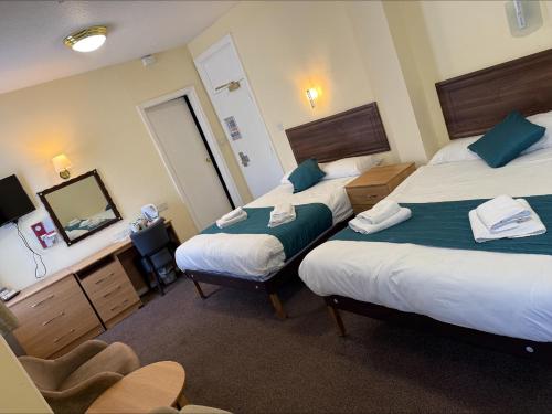 a hotel room with two beds and a mirror at The Savoy Hotel in Blackpool
