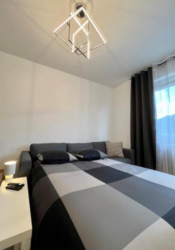 a bedroom with a bed and a table and a window at Superbe T2 à 15 min de Lyon in Sainte-Foy-lès-Lyon