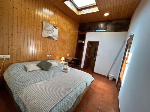 a bedroom with a bed and a skylight at Pensión Codesal in O Pedrouzo