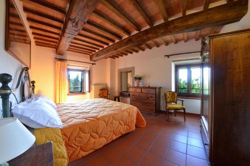 a bedroom with a bed and a desk and windows at Villa Eugenio in Cortona