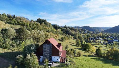 an aerial view of a barn on a hill at Cabana Ciresarii in Sohodol