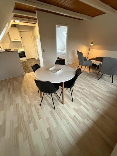 a room with a table and chairs and a piano at Folsted Ferie lejlighed nr 1 in Bindslev