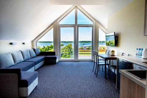 a living room with a couch and a table with chairs at Aparthotel EuforiaPort in Pisz
