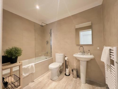 a bathroom with a toilet and a sink and a tub at Cozy 1 bed Blythswood Apartment in Glasgow