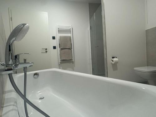 a white bathroom with a tub and a toilet at Exklusives Wohnen im historischen Wasserturm dem Highlight von Delitzsch WE317 in Delitzsch